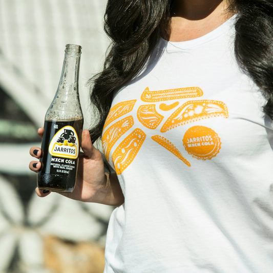 woman in white and orange crew neck shirt holding black bottle