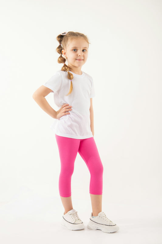 a little girl in a white shirt and pink leggings