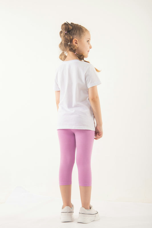 a little girl in a white shirt and pink leggings