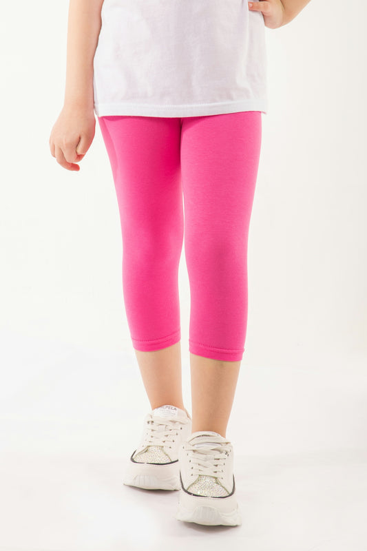 a little girl in a white shirt and pink leggings