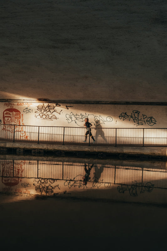 a couple of people walking on a bridge with graffiti on it