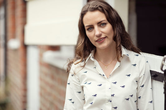 A woman in a white shirt is standing outside