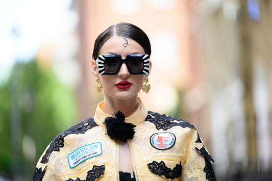 A woman wearing a yellow jacket and black sunglasses