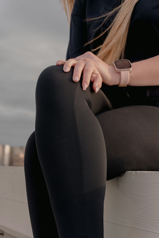 Woman wearing black leggings and a smartwatch