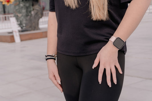Woman in black leggings and t-shirt wearing smartwatch