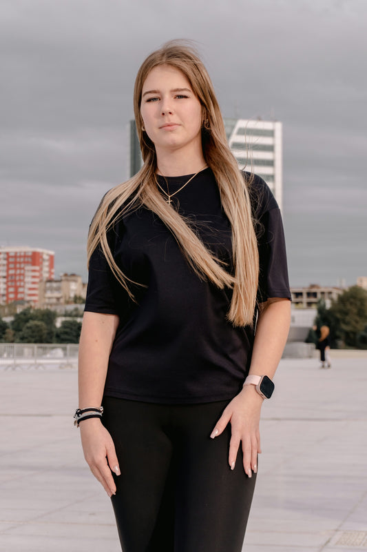 Young woman in black shirt and leggings outdoors