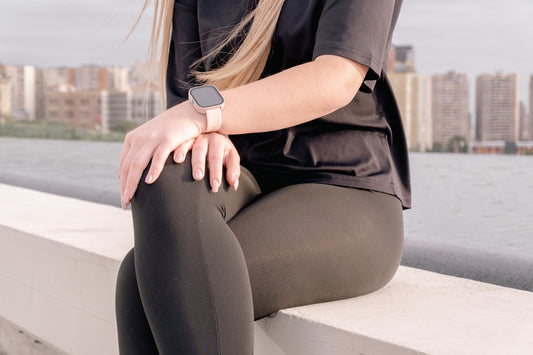Woman in black leggings and t-shirt sitting outdoors