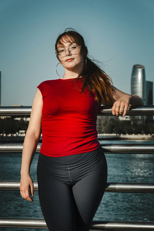 Woman in red shirt and leggings by water