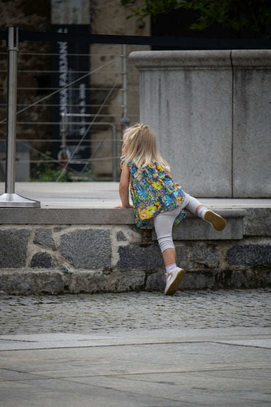 Young girl climbing stone steps outdoors.